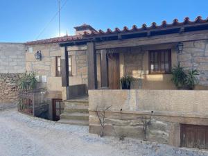 a stone house with stairs in front of it at Casa da Aldeia in Azevo