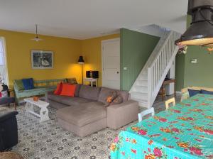 sala de estar con sofá y escalera en DE DUINDISTEL Bed by the Sea, en Dishoek