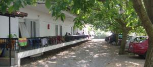 a building with cars parked next to a tree at PydnaRooms in Skála Alykís