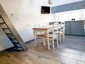 a kitchen with a wooden table and chairs at Apartament Old England in Żywiec +16 photos