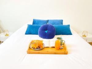 a tray of food and orange juice on a bed at AeroHome - Appart Confort - Aeroport d Orly à proximité - Parking in Athis-Mons