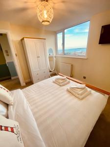 A bed or beds in a room at Lighthouse View, one min from harbour & beach