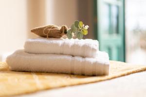 a stack of four towels with a plant on top at ***** Solaina das Burgas ***** en el Casco Viejo in Ourense