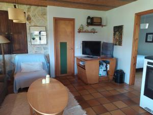 a living room with a couch and a tv and a table at Casa Torás in Vilagarcia de Arousa