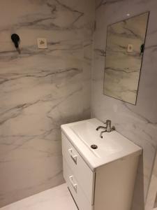 a white bathroom with a sink and a mirror at B96 suites in Brussels