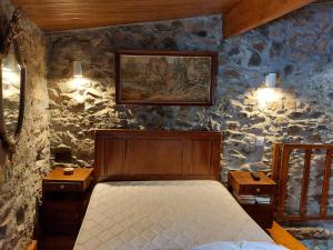 een slaapkamer met een bed in een stenen muur bij O Palheirinho - Turismo Rural - Bragança in Samil