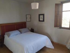 een slaapkamer met een wit bed en een raam bij Casa Torás in Vilagarcia de Arousa