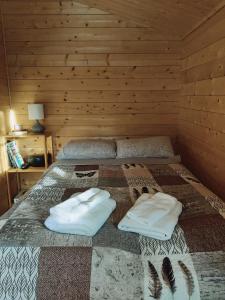 uma cama num quarto de madeira com duas almofadas em Bakkakot 2 - Cozy Cabins in the Woods em Akureyri