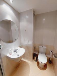 a white bathroom with a toilet and a sink at Studio Villa Park 410 in Borovets