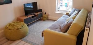 a living room with a couch and a television at Lichfield 2-bed whole apartment in Lichfield