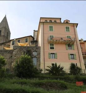 a large pink building in front of a castle at La Casa Rosa in Pigna