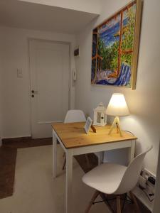 een bureau met een lamp en een witte stoel bij Kolonaki Elegant apartment in Athene