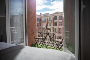 Blick auf einen Balkon mit einem Tisch und ein Gebäude in der Unterkunft Apartamento Ayuntamiento Av de La Paz in Logroño