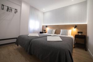 1 dormitorio con 2 camas y toallas. en Apartamento Ayuntamiento Av de La Paz en Logroño