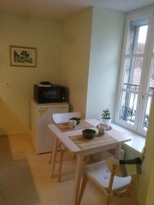 una pequeña cocina con mesa y microondas en Arbois, joli petit appartement plein centre, en Arbois
