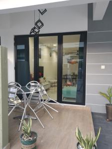 a room with two chairs and a table at 48 悠之处NO . 48, PERSIARAN ALAM IMPIAN 3 VILLA RIADAH ALAM IMPIAN PANGKOR, 32300 PANGKOR , PERAK. in Pangkor