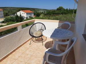 a balcony with a table and chairs and a view at Apartments Donadic I, Caska in Novalja