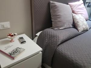 łóżko z szafką nocną z książką obok łóżka z w obiekcie La Baita Del Re Resort w mieście Ottaviano