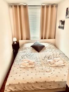 a bedroom with a bed with two slippers on it at Apartments-LUCKY STAR,NOVALJA -PAG in Novalja