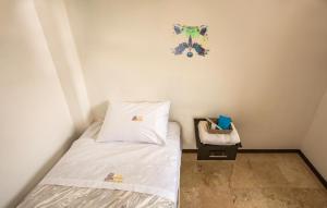 a small bedroom with a bed and a picture on the wall at Hostería Poza Rica in Poza Rica de Hidalgo