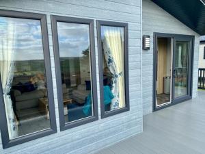 a group of windows on the side of a house at ELITE BLUE LUXURY 3 BEDROOM LODGE NEWQUAY, CORNWALL in Newquay