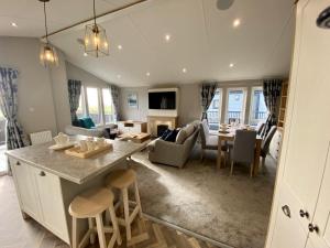 a living room with a kitchen and a dining room at ELITE BLUE LUXURY 3 BEDROOM LODGE NEWQUAY, CORNWALL in Newquay