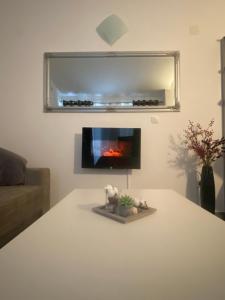 a living room with a white table with a fireplace at Apartments-LUCKY STAR,NOVALJA -PAG in Novalja