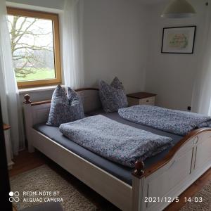 a bedroom with two beds and a window at Ferienwohnung Aicher in Kirchanschöring