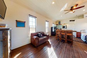 a living room with a couch and a kitchen at Honey Creek School House in Fredericksburg