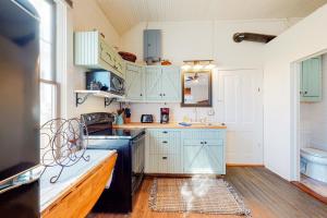 uma cozinha com armários azuis e um lavatório em Honey Creek School House em Fredericksburg