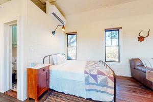1 dormitorio con 1 cama y 1 sofá en Honey Creek School House, en Fredericksburg