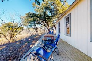 a porch with chairs and a table on a house at Honey Creek School House in Fredericksburg