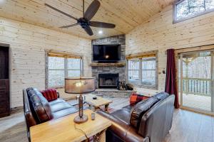 ein Wohnzimmer mit Ledermöbeln und einem Kamin in der Unterkunft Cozy Bear Cabin #2 in Sautee Nacoochee