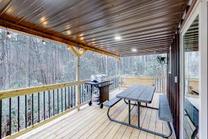 a screened in porch with a picnic table on the deck at Cozy Bear Cabin #2 in Sautee Nacoochee +29 photos