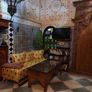 een woonkamer met een bank en een tafel bij Ryad Bab Berdaine in Meknès