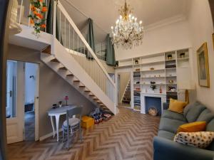 ein Wohnzimmer mit einer Treppe und einem blauen Sofa in der Unterkunft Mauthaus Schönbrunn in Wien