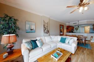 uma sala de estar com um sofá branco e uma mesa em Paradise Shores 210 em Mexico Beach