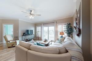 a living room with a white couch and a ceiling fan at Paradise Shores 210 in Mexico Beach