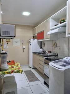 una pequeña cocina con nevera y fregadero en Life Ponta Negra, en Manaus