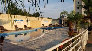 a swimming pool with chairs next to a building at Life Ponta Negra in Manaus