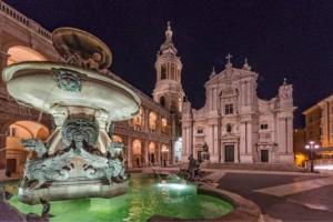 een fontein voor een groot gebouw 's nachts bij Casa Lauretana in Loreto