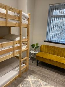 a room with bunk beds and a bench and a window at JUST SLEEP Hostel in Edinburgh