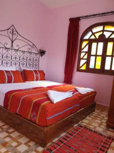 Schlafzimmer mit einem Bett und einem Fenster in der Unterkunft Gite Talassemtane in Chefchaouen