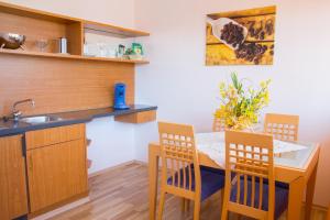 a kitchen with a table and chairs and a sink at Aparthotel Landau an der Isar in Landau an der Isar