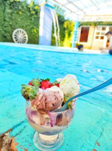 un bol de helado en una mesa junto a una piscina en Pousada SDOIS Kolonisten Haus, en Presidente Lucena