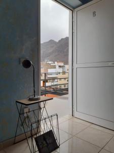 una lampada seduta su un tavolo accanto a una porta scorrevole in vetro di Apartamento La Aldea Pueblo Gran Canaria 2B a San Nicolás