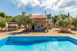a villa with a swimming pool in front of a house at Villa Jasmine - Peaceful Sunset View Retreat in Skopelos Town