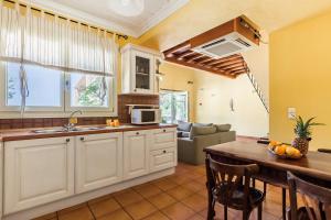 a kitchen with a sink and a table in a room at Villa Jasmine - Peaceful Sunset View Retreat in Skopelos Town +24 photos