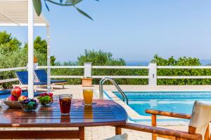 a table with fruit on it next to a swimming pool at Villa Jasmine - Peaceful Sunset View Retreat in Skopelos Town