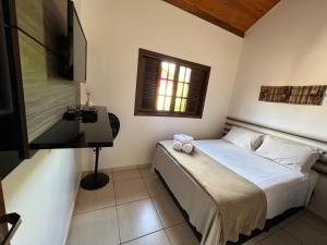 a small bedroom with a bed and a window at Juquinha Chalé in São Bento do Sapucaí